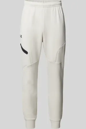 Under Armour Spodnie dresowe o kroju relaxed fit z nadrukiem z logo model ‘Unstoppable’