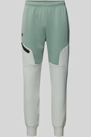 Under Armour Spodnie dresowe o kroju relaxed fit z nadrukiem z logo model ‘Unstoppable’